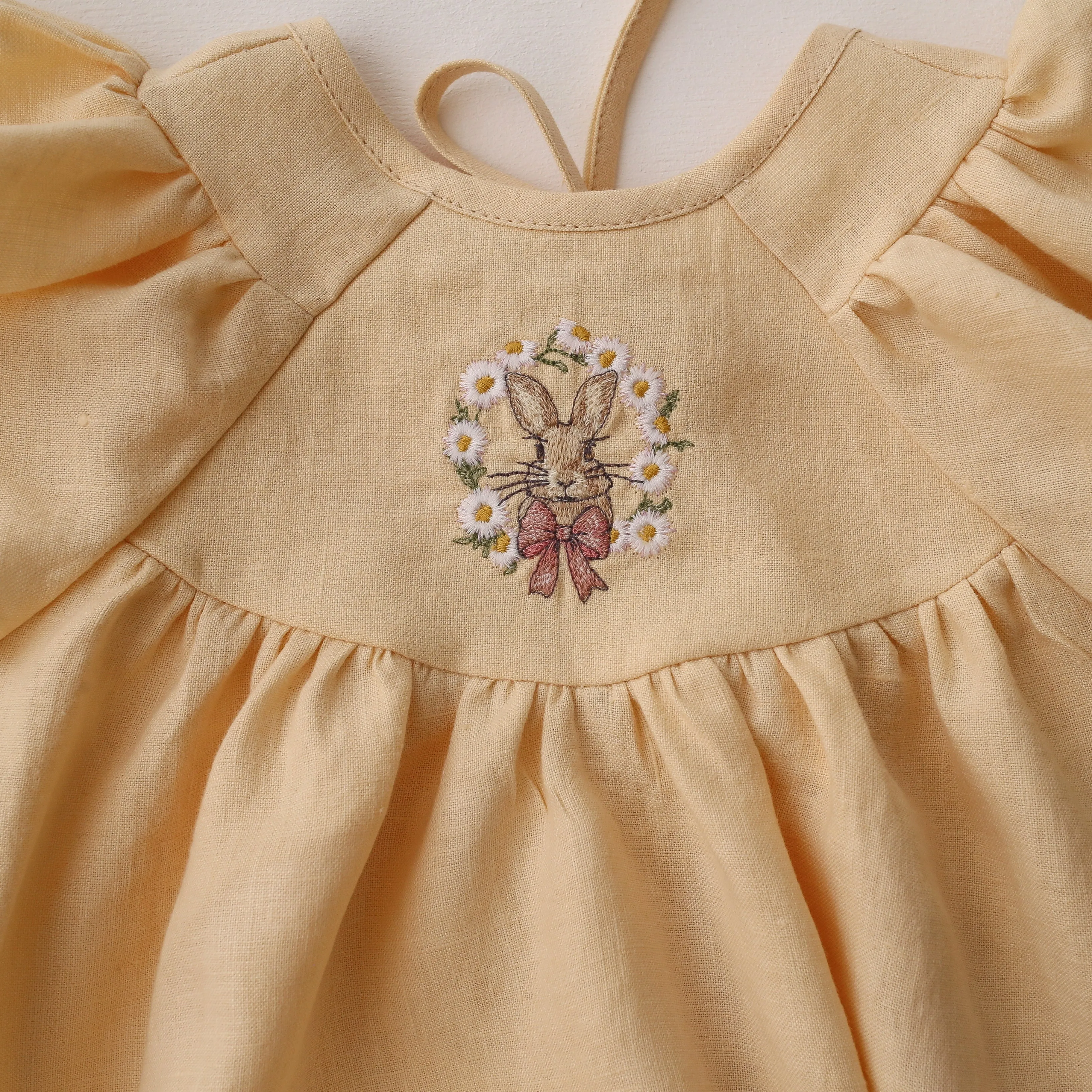 Vanilla Linen Flutter Sleeve Tie Back Bubble Playsuit with "Bunny in Daisy Wreath" Embroidery